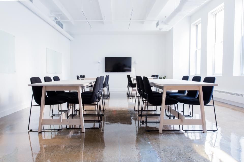 A meeting room with a long table and chairs